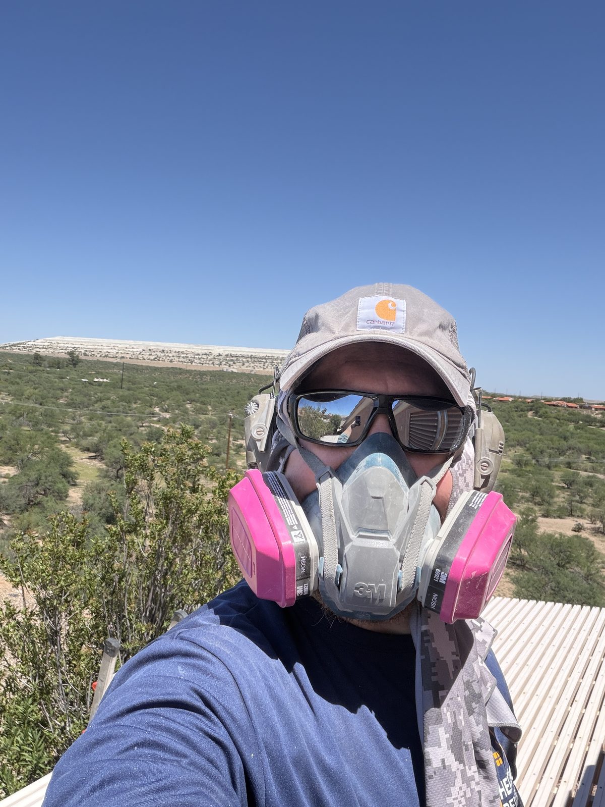Brandon on a rooftop job site wearing a respirator